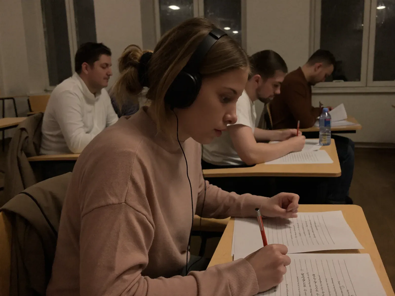 Студенти в навушниках виконують Listening